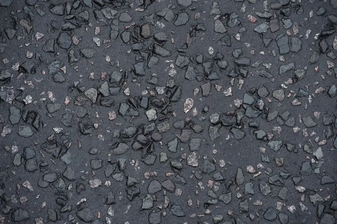 Illustrative close-up of wet asphalt aggregate. Not a Hamilton Asphalts surface.